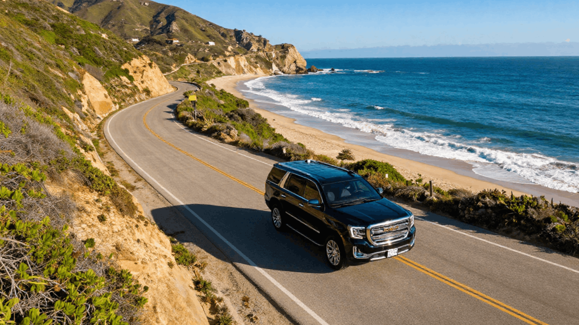 Black 2025 GMC Yukon Denali on the coast highway above the Pacific